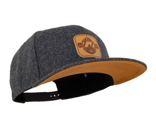 Snowboard Snapback Cap von Jumping Bird - Modell Leogang in dunkelgrau/orange mit Badge in Lederoptik und Logo-Stick seitlich