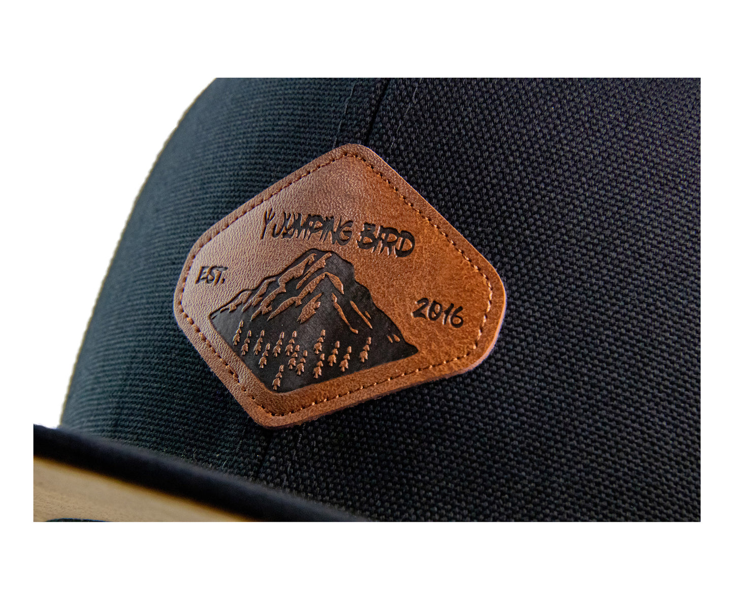 Snapback Cap von Jumping Bird - Modell Titlis in schwarz mit Badge in Lederoptik und Logo-Stick seitlich