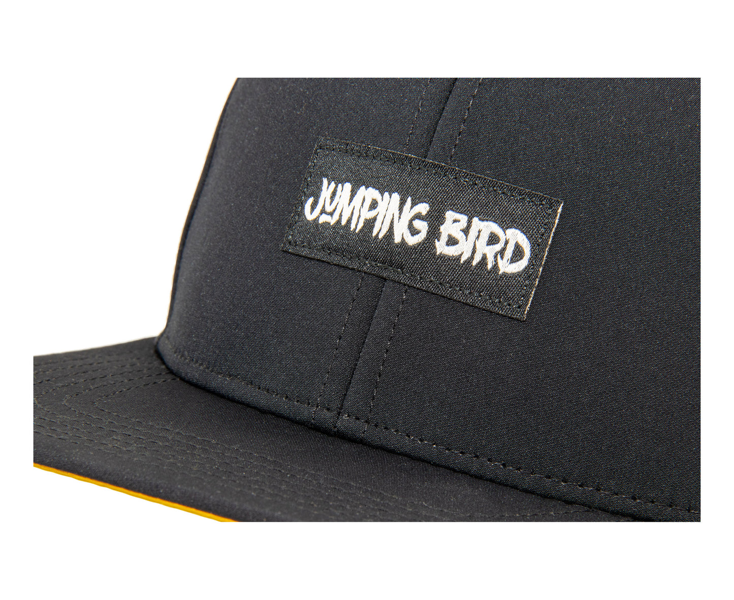 Performance Snapback Cap von Jumping Bird - Modell Felskinn in schwarz/senfgelb mit sportivem Badge und Logo-Stick seitlich