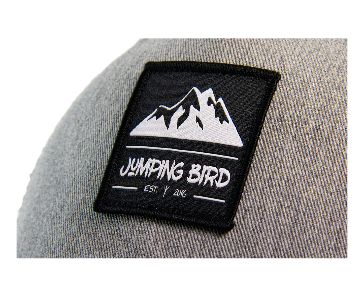 Trucker Cap von Jumping Bird - Modell Kuchenspitze in hellgrau mit elegantem Badge und Logo seitlich
