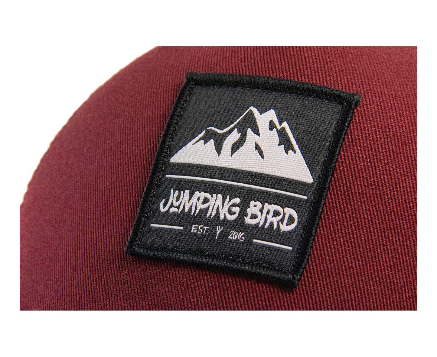 Trucker Cap von Jumping Bird - Modell Piz Cengalo in bordeaux mit elegantem Badge und Logo seitlich
