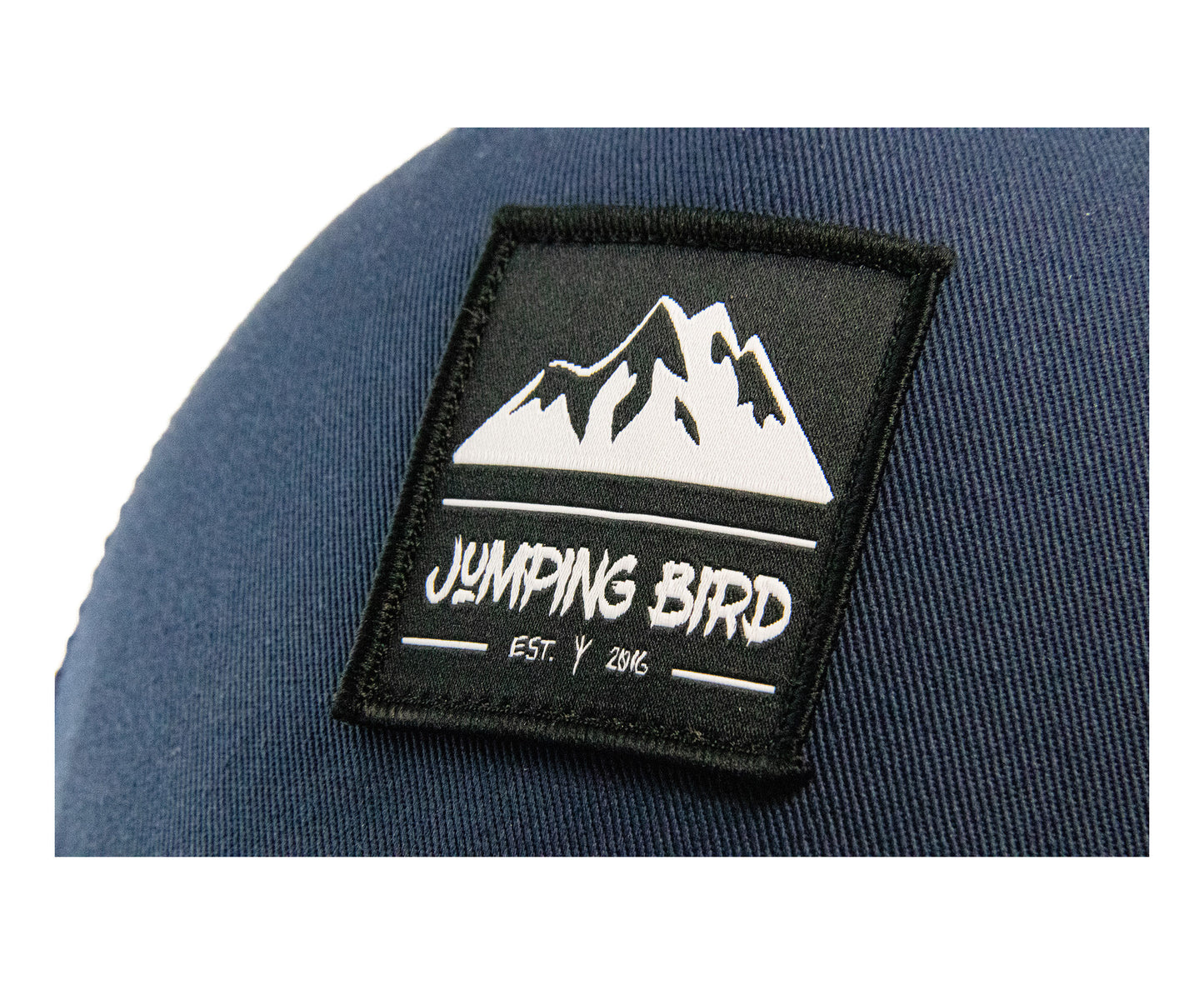 Trucker Cap von Jumping Bird - Modell Mitterkamm in dunkelblau mit elegantem Badge und Logo seitlich