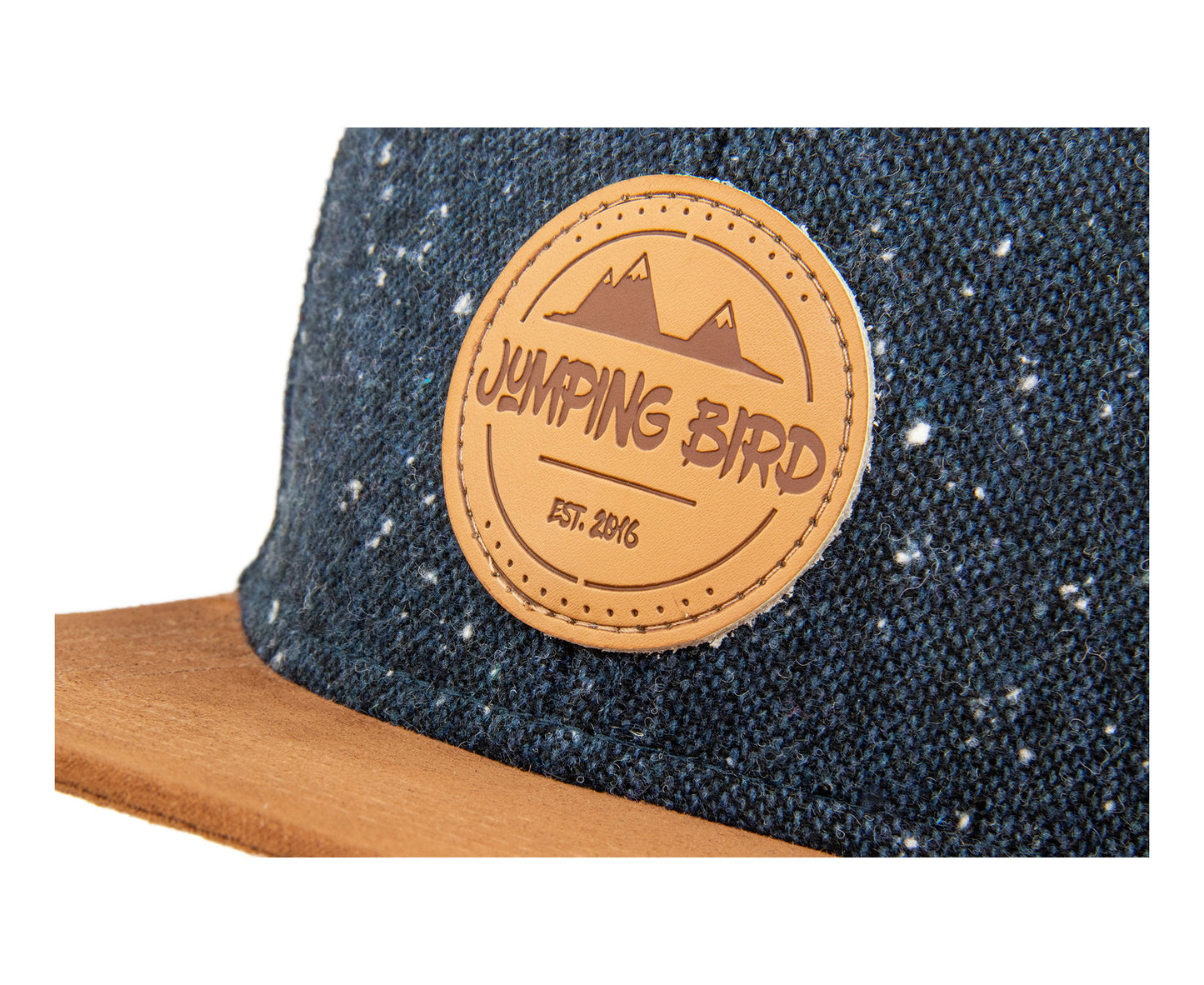 Snapback-Cap von Jumping Bird in Anthrazitblau-Braun mit geprägtem Lederoptik-Patch vorn und seitlichem Logostick