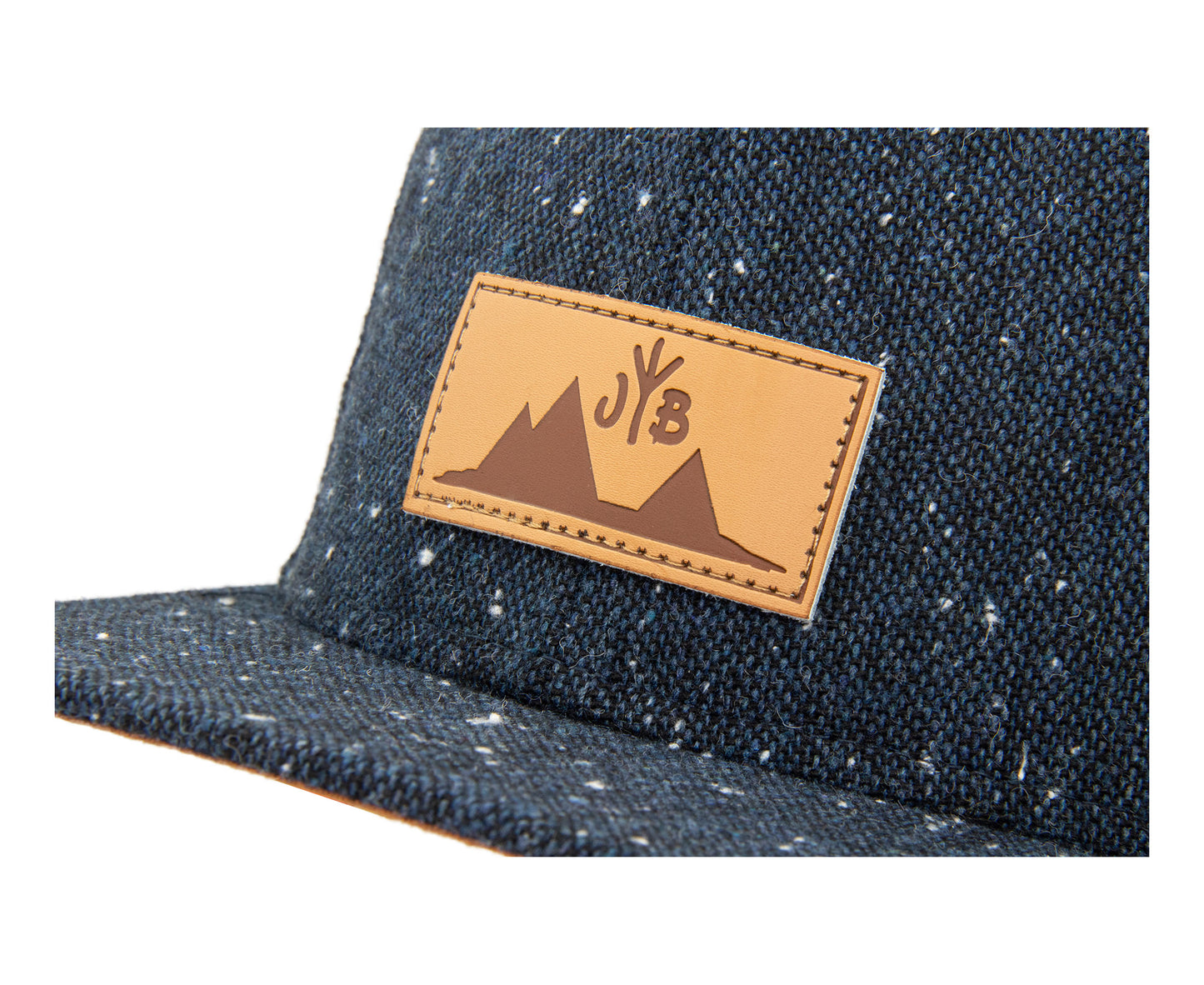 Snapback-Cap von Jumping Bird in Anthrazitblau meliert mit geprägtem Lederoptik-Patch vorn und seitlichem Logostick