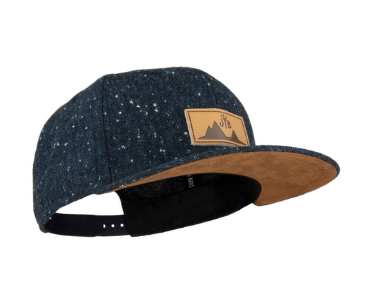 Snapback-Cap von Jumping Bird in Anthrazitblau meliert mit geprägtem Lederoptik-Patch vorn und seitlichem Logostick