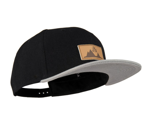 Snapback-Cap von Jumping Bird in Schwarz-Grau mit geprägtem Lederoptik-Patch vorn und seitlichem Logostick