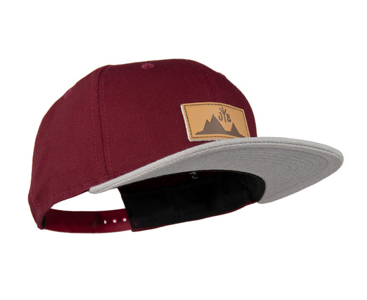 Snapback-Cap von Jumping Bird in Bordeaux-Grau mit geprägtem Lederoptik-Patch vorn und seitlichem Logostick
