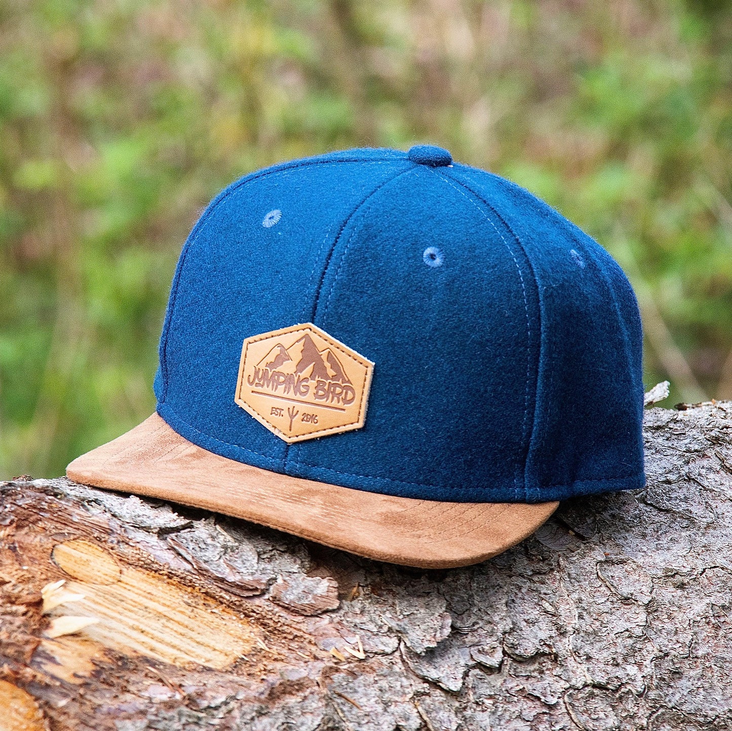 Filz Snapback Cap von Jumping Bird - Modell Parrotspitze in mitternachtsblau/braun (Filz) mit Badge in Lederoptik und Logo-Stick seitlich