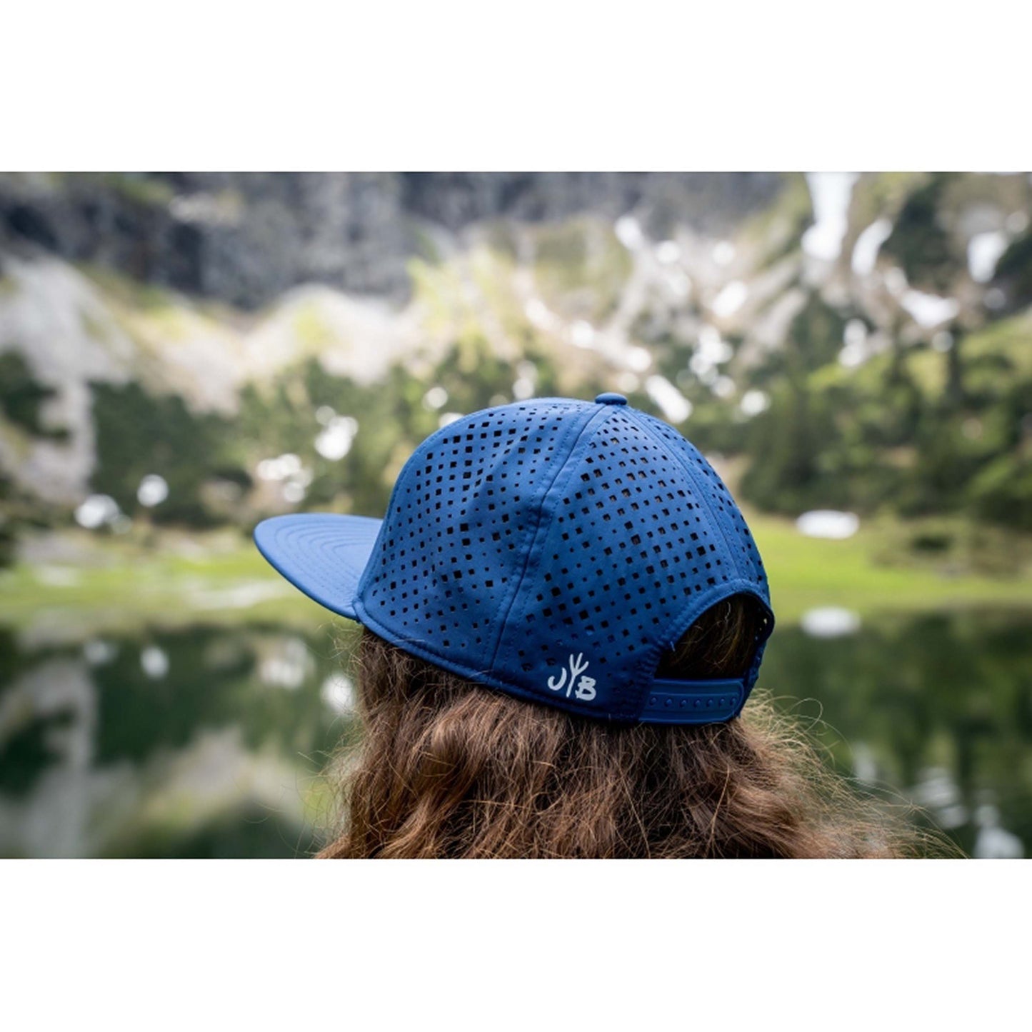 Performance Snapback Cap von Jumping Bird - Modell Adlerhorn in dunkelblau/senfgelb mit sportivem Badge und Logo-Stick seitlich