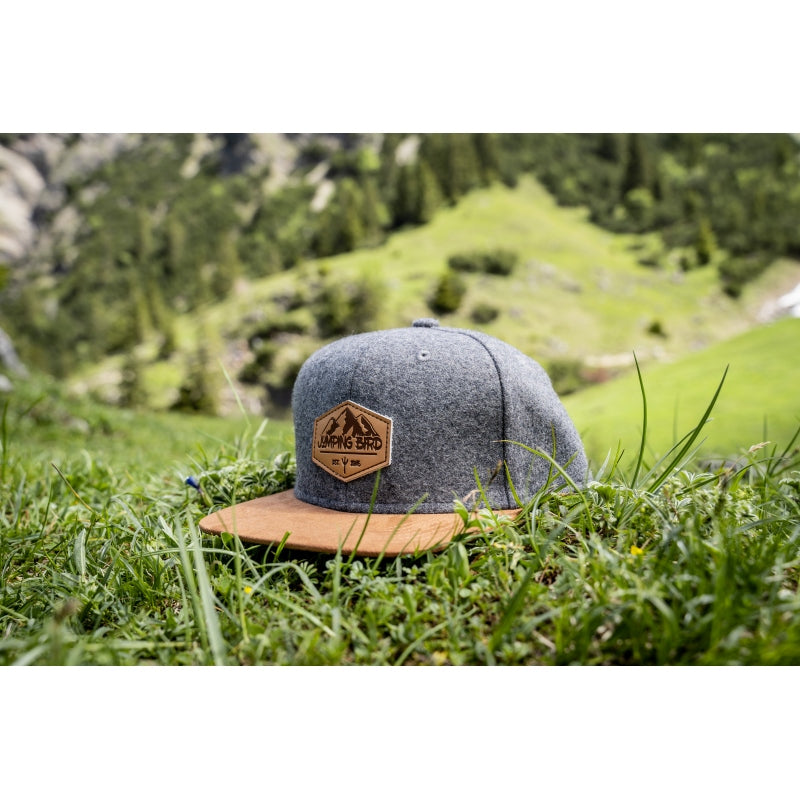 Filz-Snapback von Jumping Bird in Steingrau-Braun mit geprägtem Lederoptik-Patch vorn und seitlichem Logostick