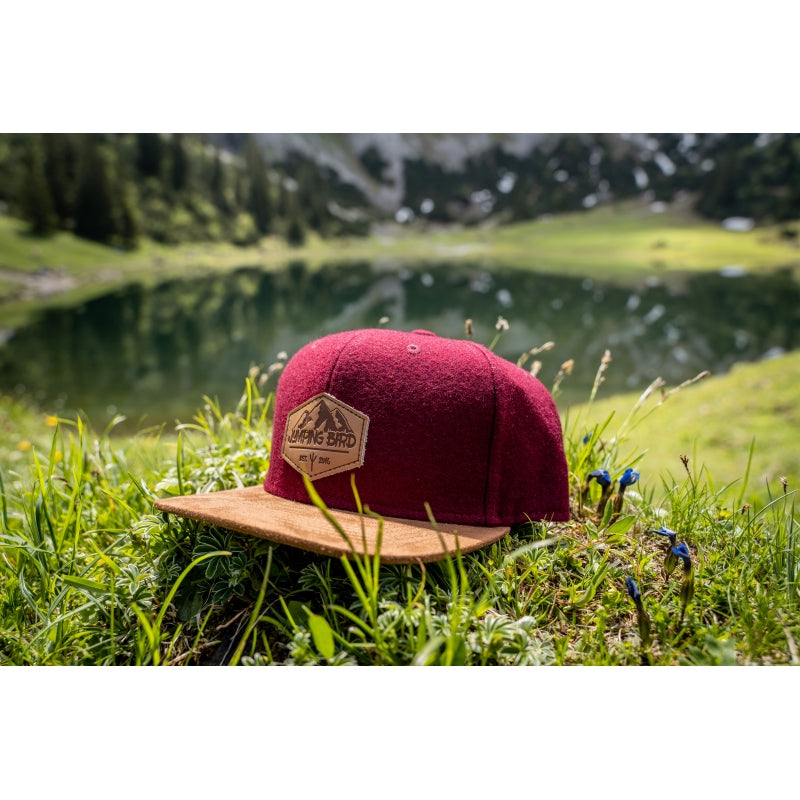 Filz-Snapback von Jumping Bird in Dunkelrot-Braun mit geprägtem Lederoptik-Patch vorn und seitlichem Logostick