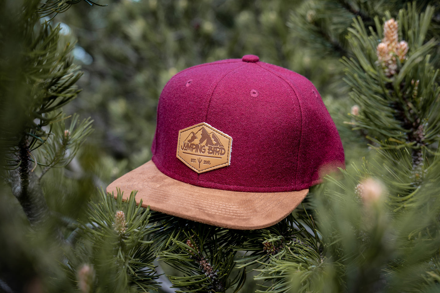 Filz-Snapback von Jumping Bird in Dunkelrot-Braun mit geprägtem Lederoptik-Patch vorn und seitlichem Logostick