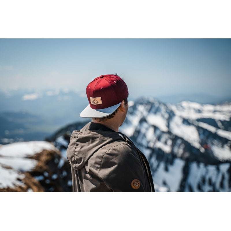 Snapback-Cap von Jumping Bird in Bordeaux-Grau mit geprägtem Lederoptik-Patch vorn und seitlichem Logostick