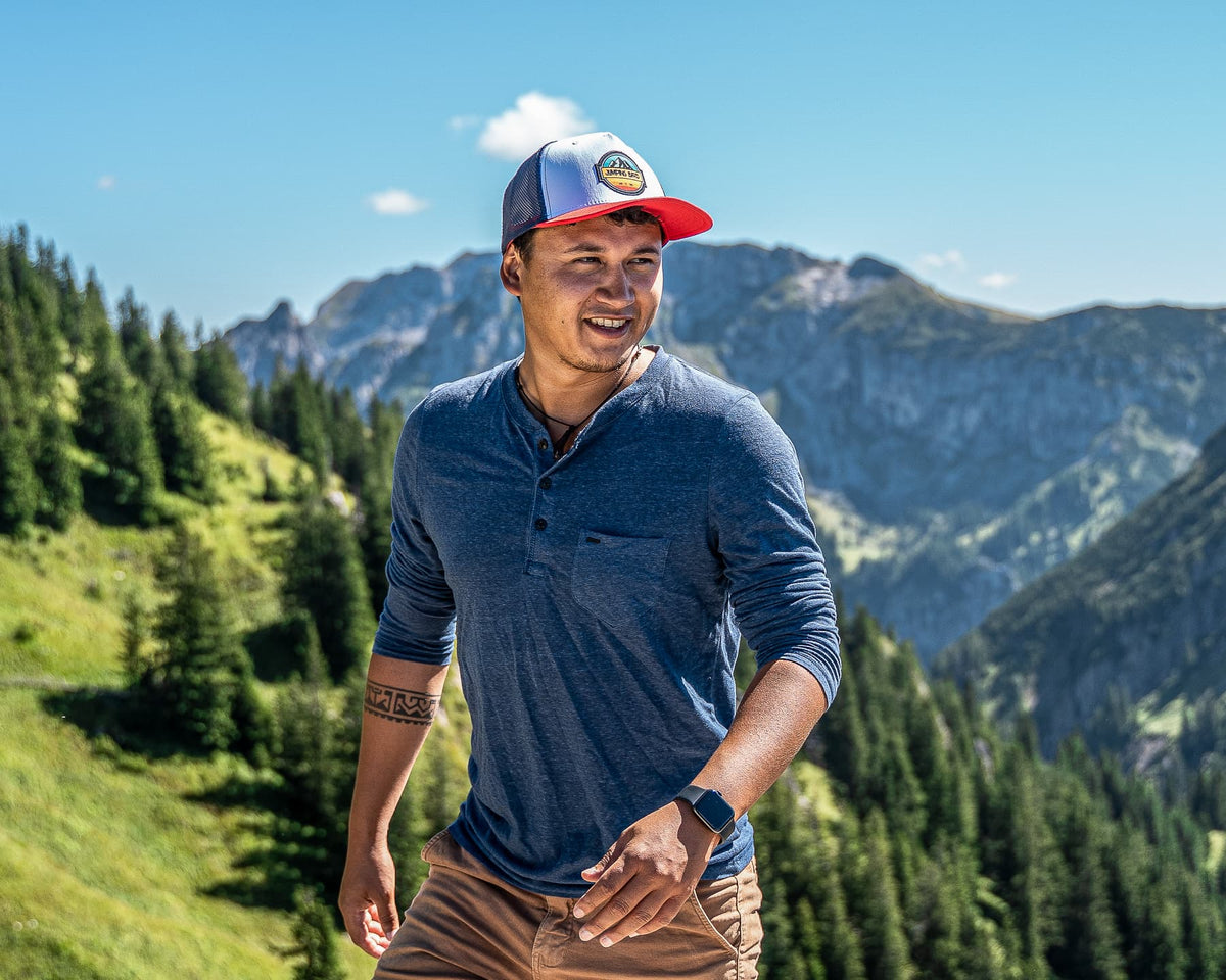 Mann mit Jumping Bird Cap beim Wandern in den Bergen
