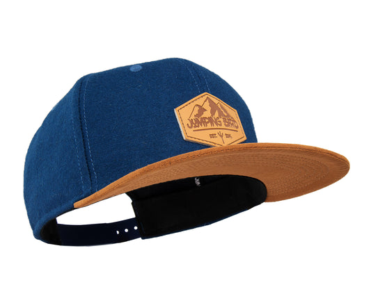 Filz Snapback Cap von Jumping Bird - Modell Parrotspitze in mitternachtsblau/braun (Filz) mit Badge in Lederoptik und Logo-Stick seitlich
