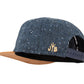 Snapback-Cap von Jumping Bird in Anthrazitblau-Braun mit geprägtem Lederoptik-Patch vorn und seitlichem Logostick