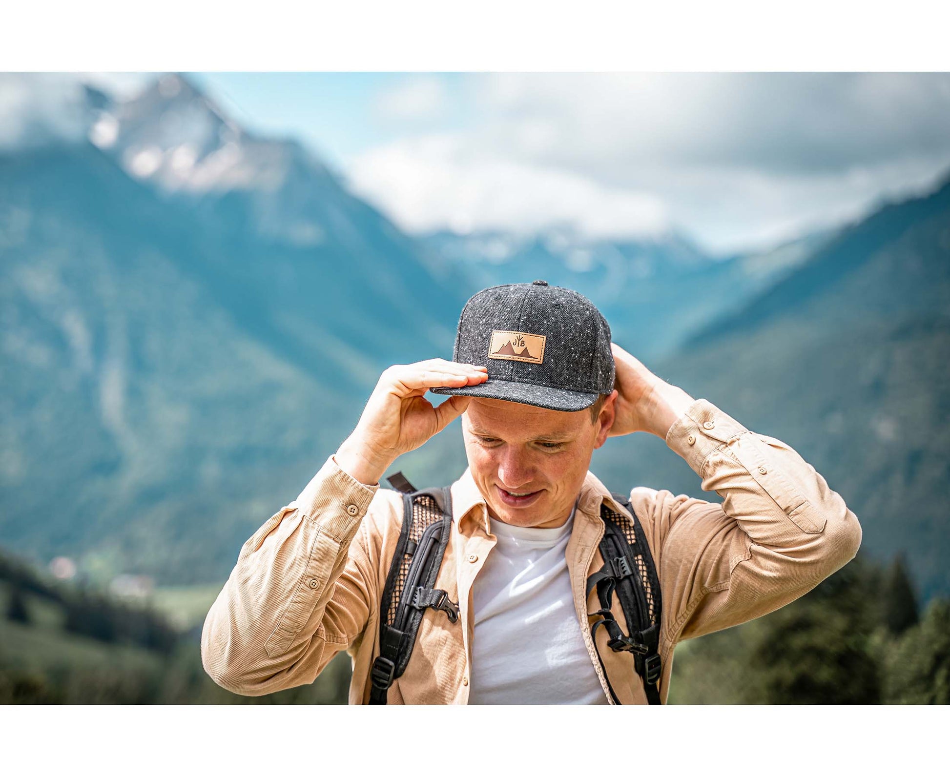 Snapback-Cap von Jumping Bird in Dunkelgrau meliert mit geprägtem Lederoptik-Patch vorn und seitlichem Logostick