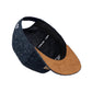 Snapback-Cap von Jumping Bird in Anthrazitblau meliert mit geprägtem Lederoptik-Patch vorn und seitlichem Logostick