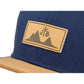 Snapback-Cap von Jumping Bird in Blau-Braun mit geprägtem Lederoptik-Patch vorn und seitlichem Logostick