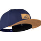 Snapback-Cap von Jumping Bird in Blau-Braun mit geprägtem Lederoptik-Patch vorn und seitlichem Logostick