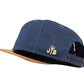 Snapback-Cap von Jumping Bird in Ozeanblau-Braun mit geprägtem Lederoptik-Patch vorn und seitlichem Logostick