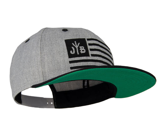 Snapback-Cap von Jumping Bird in Hellgrau-Schwarz mit gesticktem Flaggen-Design vorn, Logostick seitlich und grünem Schirm