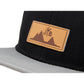 Snapback-Cap von Jumping Bird in Schwarz-Grau mit geprägtem Lederoptik-Patch vorn und seitlichem Logostick