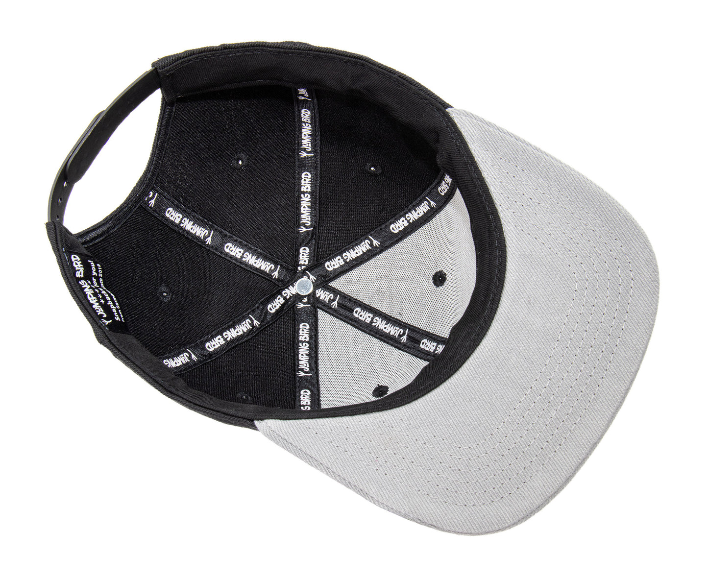 Snapback-Cap von Jumping Bird in Schwarz-Grau mit geprägtem Lederoptik-Patch vorn und seitlichem Logostick