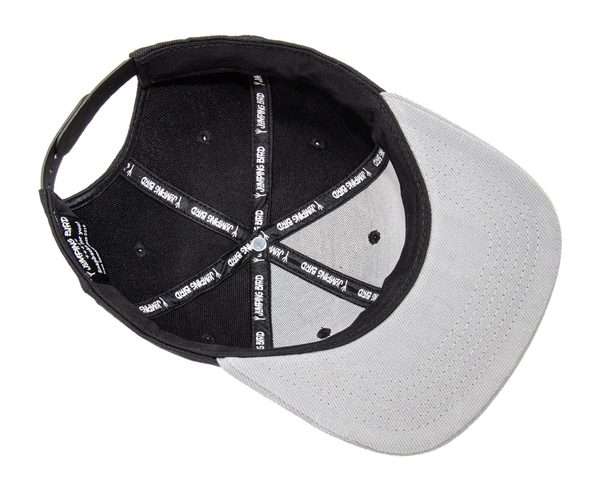 Snapback-Cap von Jumping Bird in Schwarz-Grau mit geprägtem Lederoptik-Patch vorn und seitlichem Logostick