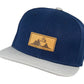 Snapback-Cap von Jumping Bird in Blau-Grau mit geprägtem Lederoptik-Patch vorn und seitlichem Logostick