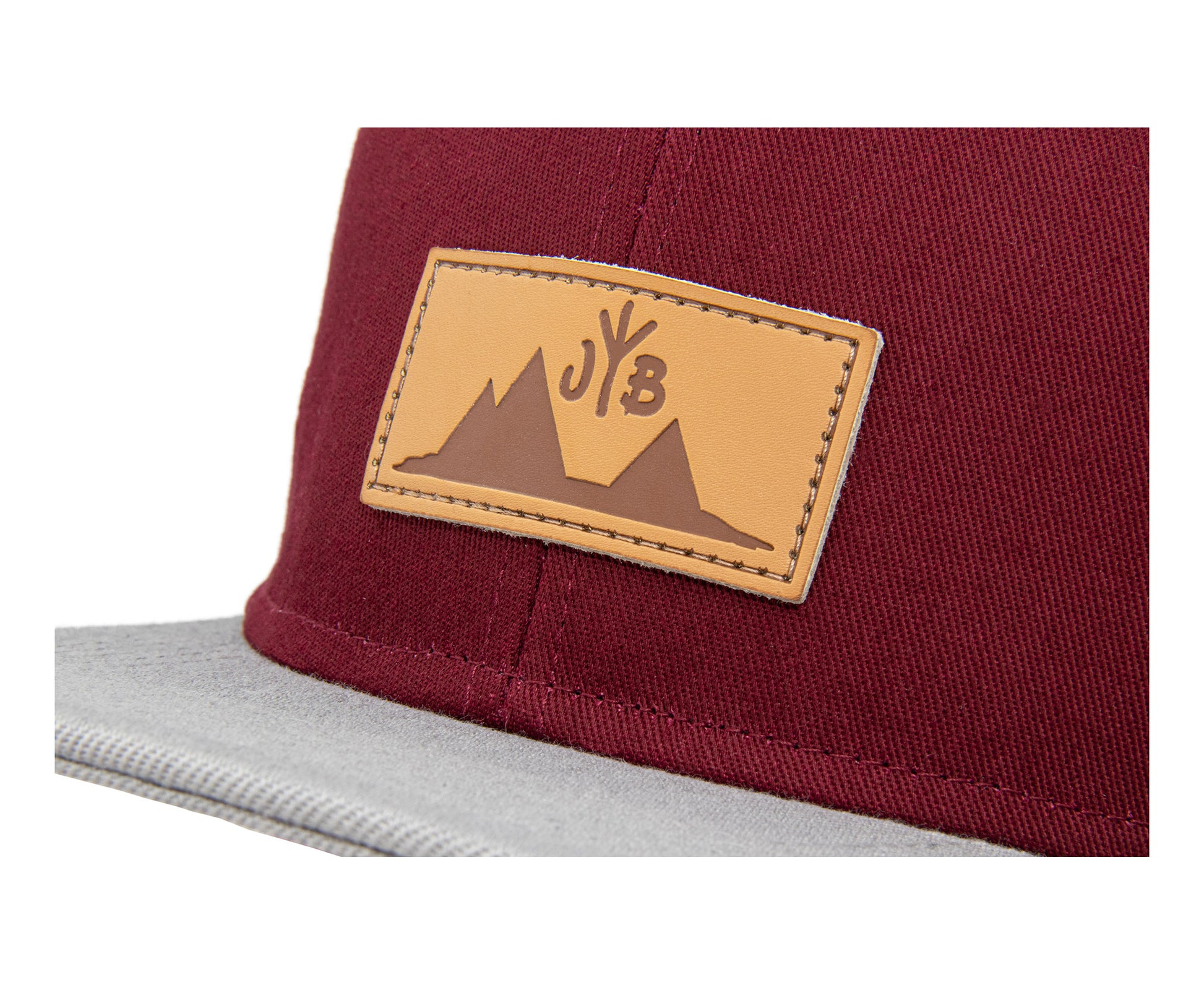 Snapback-Cap von Jumping Bird in Bordeaux-Grau mit geprägtem Lederoptik-Patch vorn und seitlichem Logostick