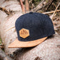 Filz-Snapback von Jumping Bird in Anthrazit-Braun mit geprägtem Lederoptik-Patch vorn und seitlichem Logostick