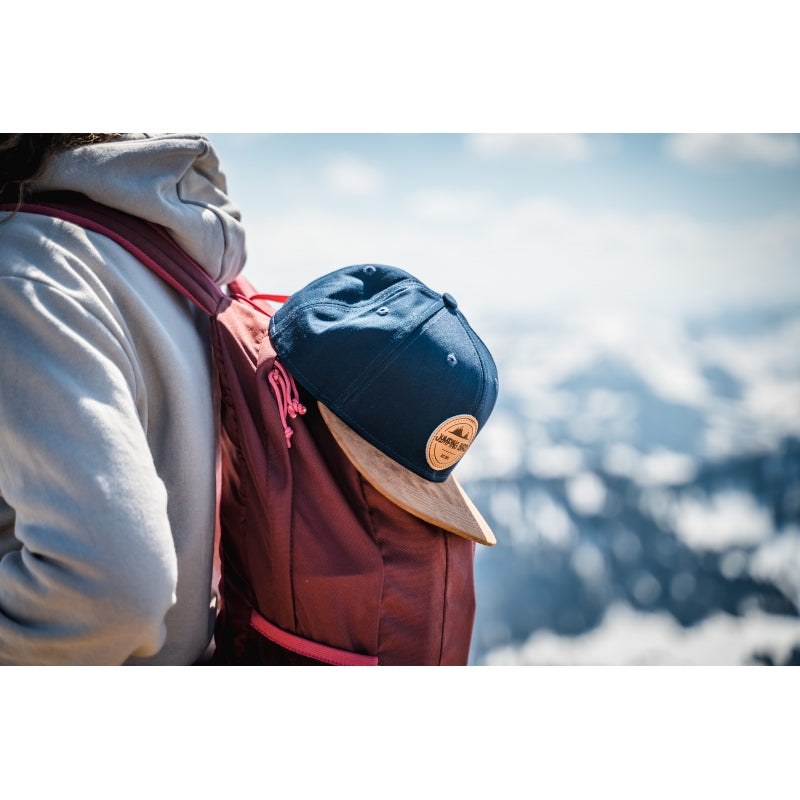 Snapback-Cap von Jumping Bird in Ozeanblau-Braun mit geprägtem Lederoptik-Patch vorn und seitlichem Logostick