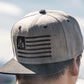 Snapback-Cap von Jumping Bird in Hellgrau-Schwarz mit gesticktem Flaggen-Design vorn, Logostick seitlich und grünem Schirm